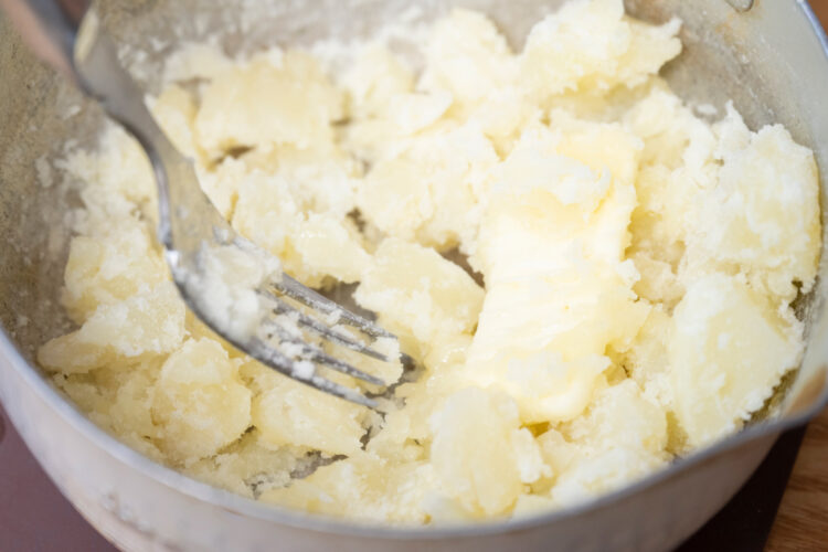 鍋の中のじゃがいもをつぶす